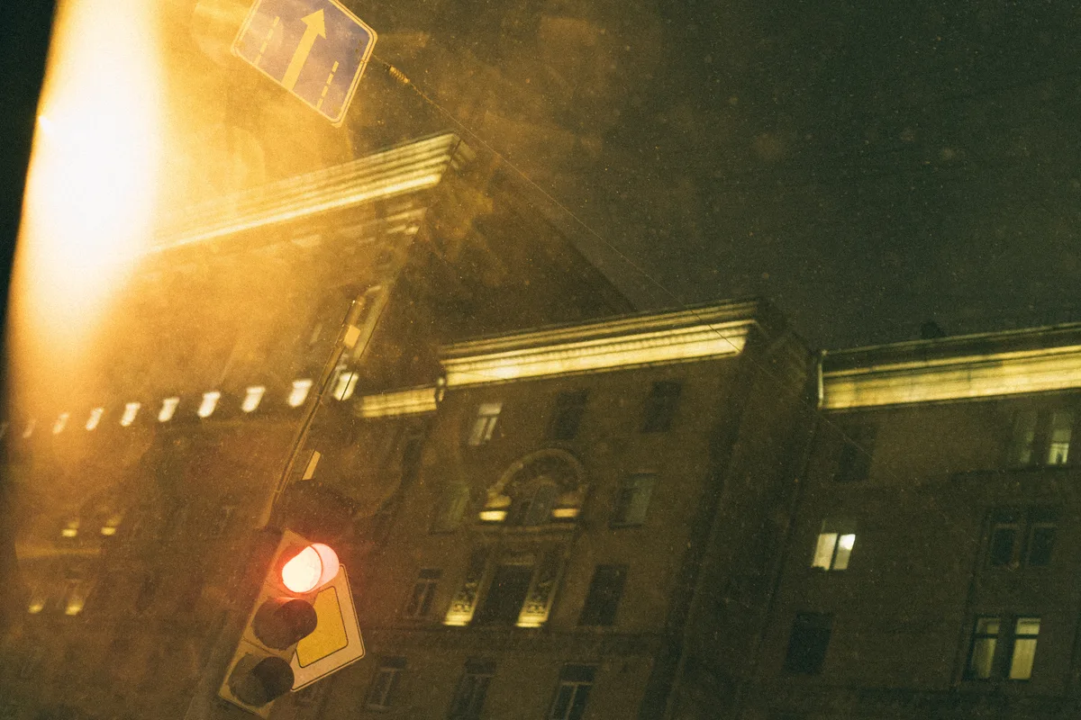A building facade and traffic signal behind a broad golden flare.