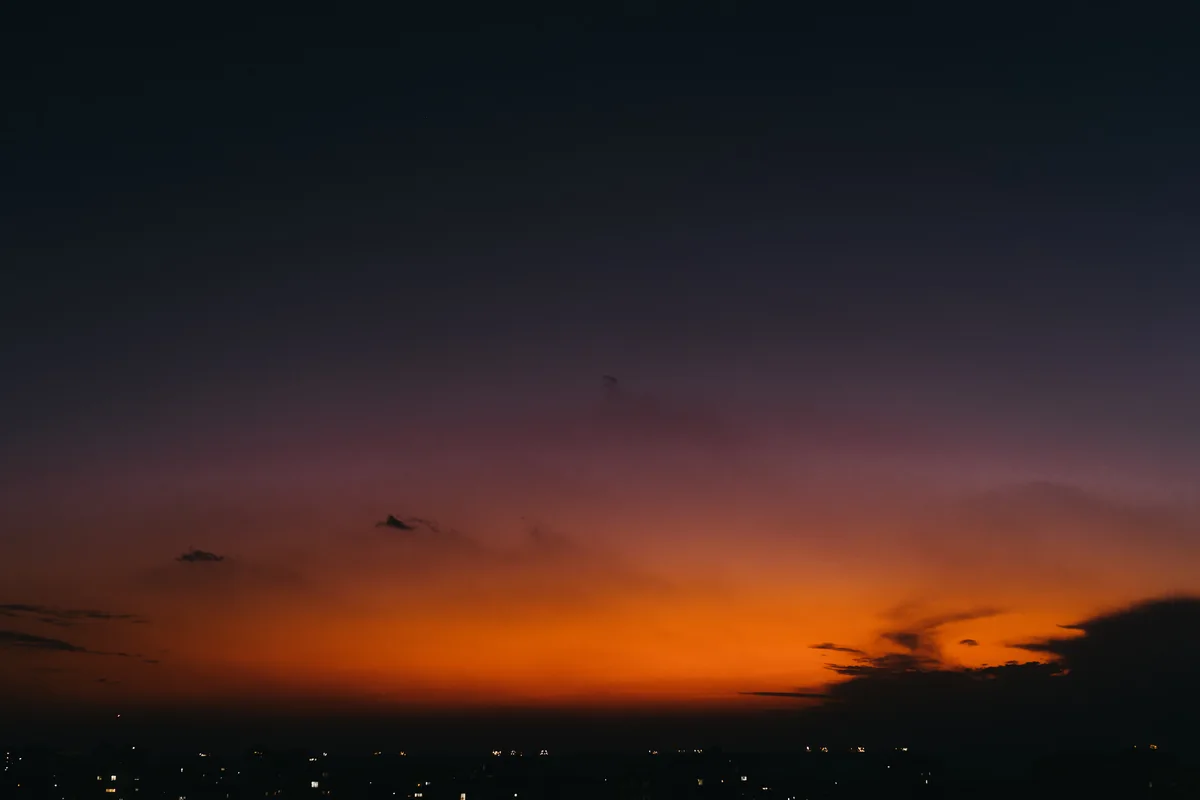 An orange-red horizon beneath a darkening blue sky.