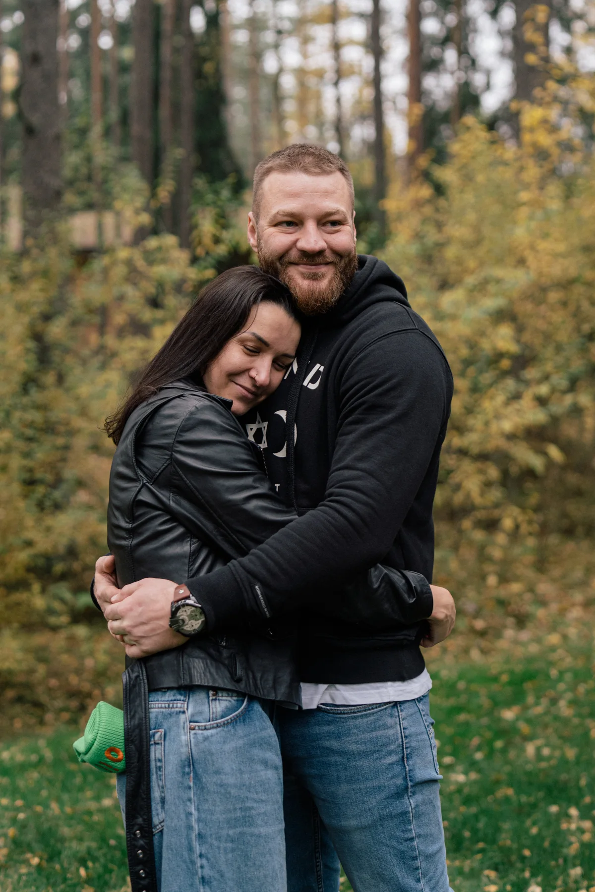 Two people embracing among trees.